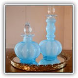 G27. Pair of decorative glass bottles.  One with chips to bottom of stopper. 7.5"T and 5"T - $16