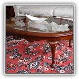 F8. Oval wood and beveled glass top coffee table. Dimensions: 32"D x 47.5W. Condition: Water stain on one side - $195
