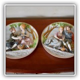 E15. Pair of decorative hanging wall plates with relief of children and grapes. 11"W - $48 for the pair