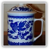 P41. Blue and white covered mug. Small chip.