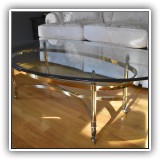 F03. Brass and glass oval coffee table.  16.25"h x 49"w x 28.25"d - $250