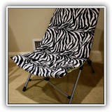 F66. Green folding chair with zebra print slip cover. - $14