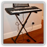 E10. Yamaha electric keyboard with stand and sustain pedal. Model PSR-E203. - $65